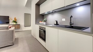 A modern kitchen with a built-in oven, a stainless steel sink, and a large window above the counter. - Mamo Florence - Venere & Zefiro Apartments (Florence)