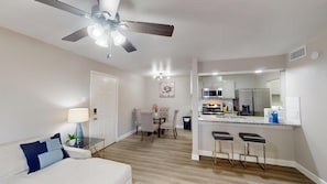 A modern apartment with a dining area, kitchen, and a ceiling fan. - I040 – World Cup Stay - 18 min to AT&T - Sleeps 4 - Public Transit (Irving)
