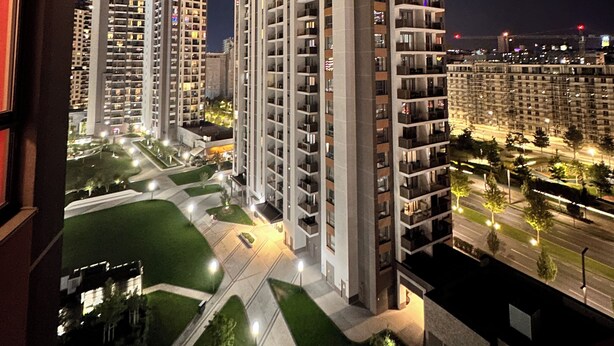 A high-rise residential building with multiple balconies, a well-lit parking area, and a landscaped courtyard. - MILO Lux Apartments 2 - Belgrade
Waterfront - Aqua (Beograd)