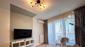 A modern living room with a flat-screen TV, a hanging chair, a round coffee table, and a sofa. - MILO Lux Apartments 2 - Belgrade
Waterfront - Aqua (Beograd)