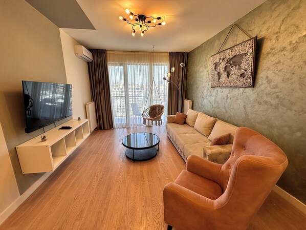 A modern living room with a sofa, armchair, and a TV on a stand. - MILO Lux Apartments 2 - Belgrade
Waterfront - Aqua (Beograd)