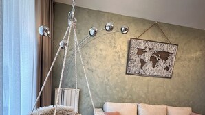 A living room with a hanging macrame chair, a cushioned sofa, a world map artwork, and a hanging lamp. - MILO Lux Apartments 2 - Belgrade
Waterfront - Aqua (Beograd)