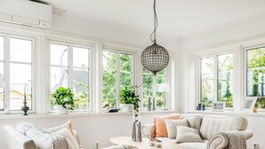 A bright, well-lit room with large windows, a round wooden table, and two sofas with cushions. - Haveliden by Interhome (Hällevik)