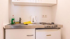A kitchenette with a stove, sink, and cabinets. - Chic Cozy Studio, 15 min to City Center (Vienna)