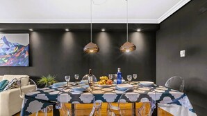 A dining area with a round table, clear chairs, and pendant lighting. - Eslanzarote Wanderlust house (Arrecife)