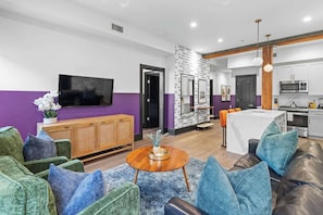A modern living room with a sofa, a coffee table, and a TV.
