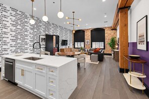 Cocina moderna con una isla central, armarios blancos y salpicadero con texto repetido.