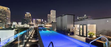 Una piscina en la azotea con un horizonte urbano de fondo.