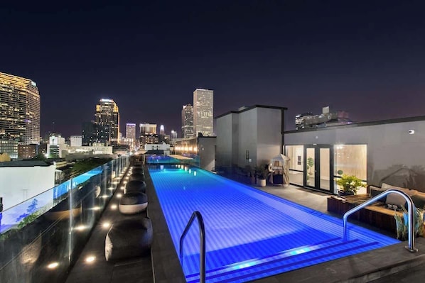Una piscina en la azotea con un horizonte urbano de fondo.