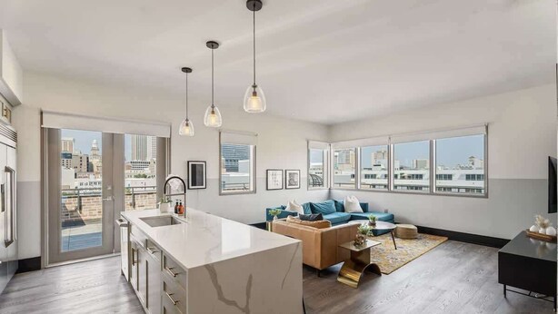 Un apartamento moderno con cocina, sala de estar y ventanas amplias con vistas a la ciudad.