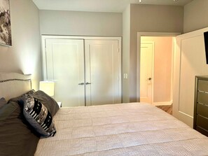A bedroom with a bed, a wardrobe, and a door leading to another room. - MCK104 - Apt|Patio|15mi to Toyota Stadium|Sleeps 2 (McKinney)
