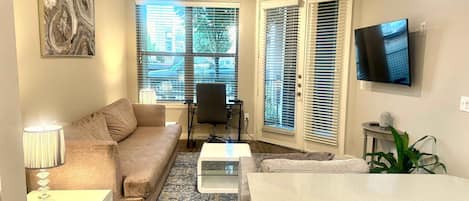 Un salon comprenant un canapé, une table basse, un téléviseur et un ventilateur de plafond.
