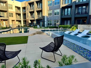 A modern outdoor pool area with lounge chairs and a clear view of the surrounding buildings. - MCK104 - Apt|Patio|15mi to Toyota Stadium|Sleeps 2 (McKinney)