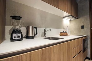A modern kitchen with a blender, kettle, and sink. - Perfect Location, Balcony, Rooftop Pool, Gym (Tulum)