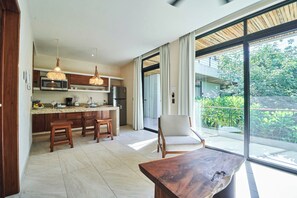 A modern kitchen with a central island, wooden stools, and pendant lighting. - Tulum Penthouse with Rooftop Pool and BBQ Grill (Tulum)