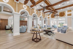 A spacious living room with high ceilings, wooden beams, and a large ceiling fan. - Fabulous Oceanfront Gem | Inlet #107 (New Smyrna Beach)