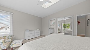 A bedroom with a large bed, a dresser, a chair, and a skylight. - Cozy 3-bedroom condo with AC and WiFi in charming Virginia Beach (Virginia Beach)