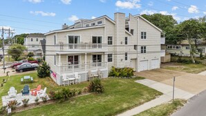 A two-story house with a balcony, a lawn with outdoor furniture, and a garage. - Cozy 3-bedroom condo with AC and WiFi in charming Virginia Beach (Virginia Beach)