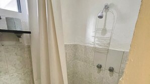 A bathroom with a shower area, a towel rack, and a toilet. - Studio w/ kitchen, AC, Wi-Fi. Sleeps 3. Near beaches & pedestrian street | Isla Mujeres' Punta Norte (Isla Mujeres)
