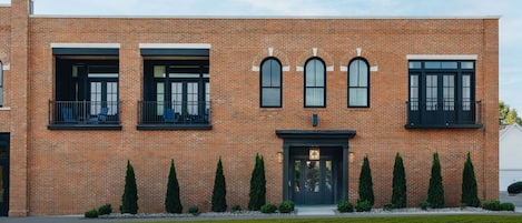 A modern brick building with a symmetrical facade, large windows, and a central entrance.