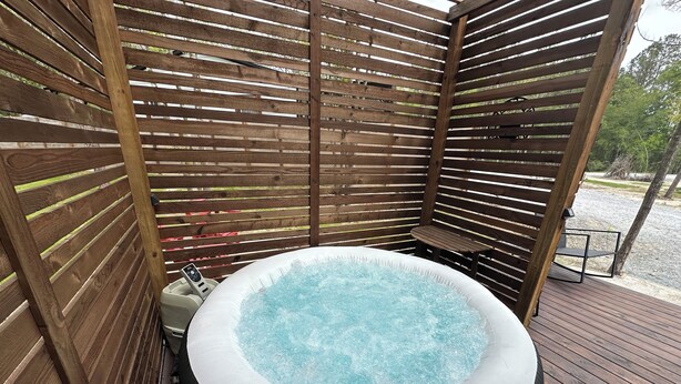 Un bain à remous installé dans un gazebo en bois, avec un panneau de commande.