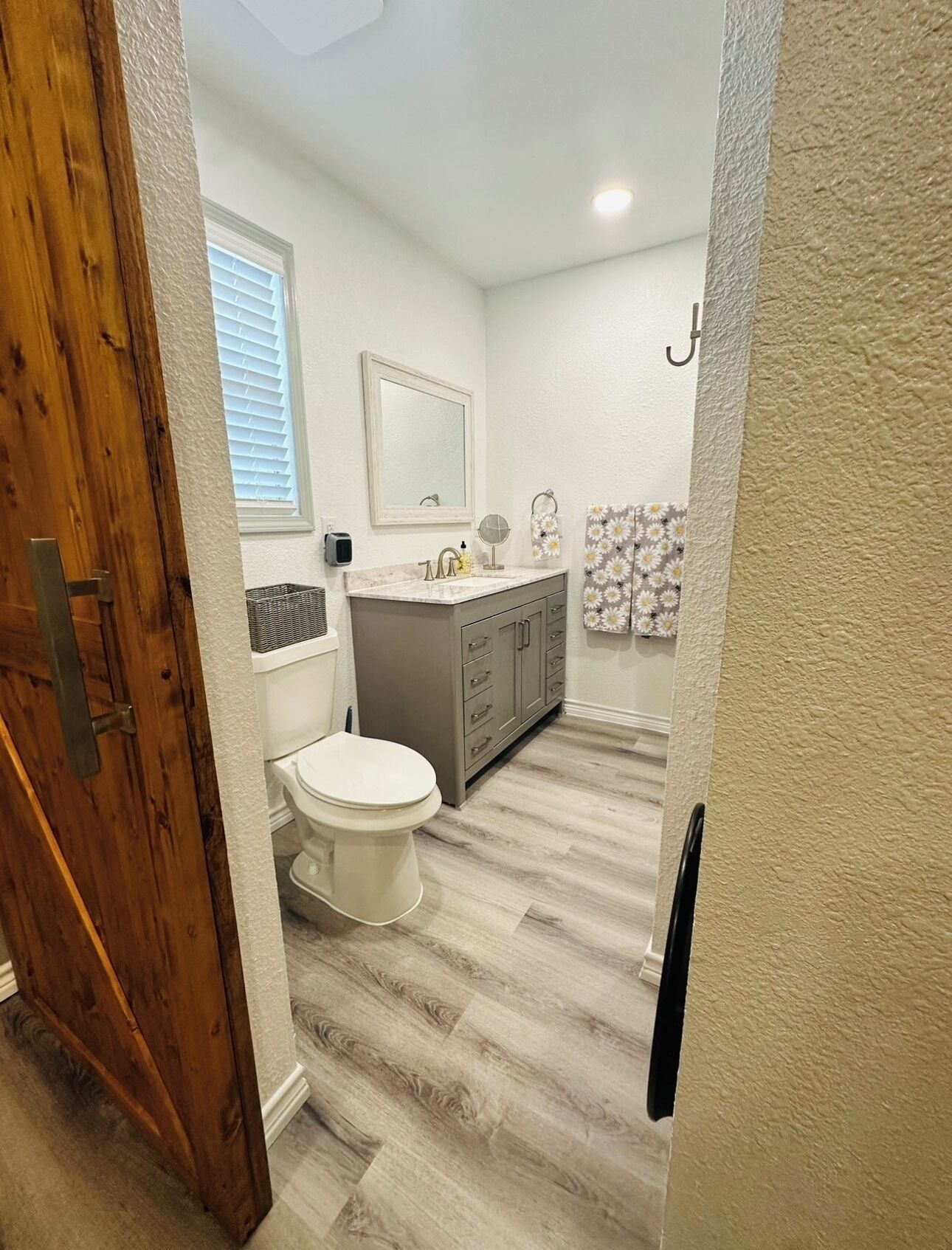 A bathroom with a toilet, sink, and vanity.