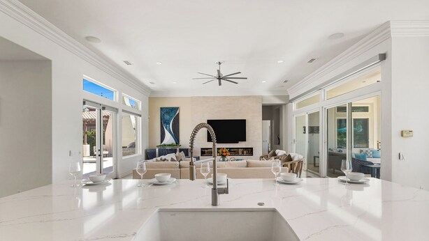 A spacious living room with a large white marble countertop, a built-in kitchen sink, and a ceiling fan. - Desert Flower - Contemporary villa at PGA West (La Quinta)