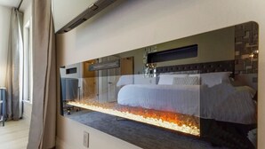 A modern hotel room with a large bed, a built-in heater, and a large mirror reflecting the room. - Serene 1 BR Condo at Silverado Resort (Napa)