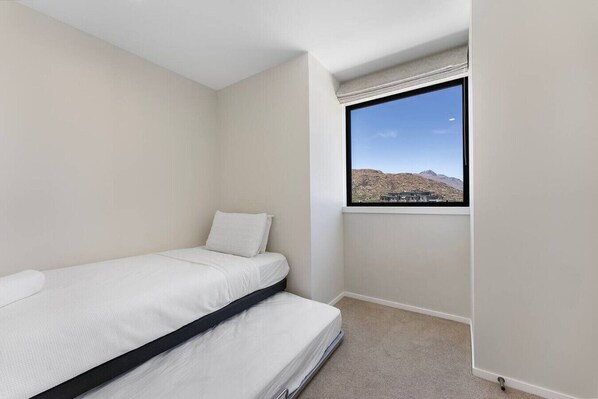 Una habitación pequeña con cama individual y ventana con vistas a la montaña.