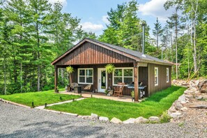 A rustic cabin with a porch, outdoor seating, and a stone pathway. - Cozy, stylish, and surrounded by nature; Sojourn Hideaway is the perfect getaway (Windsor)