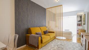 Een moderne woonkamer met een bank, een bijzettafeltje en een eethoek.