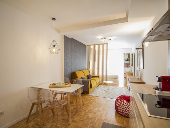 Un espace de vie moderne comprenant un coin repas, un canapé et une cuisine.