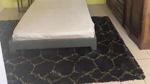 A bedroom with a bed, a nightstand, a wardrobe, and a ceiling fan. - Charming 2 bedroom house with AC, WIFI  (Jimmit mahaut)