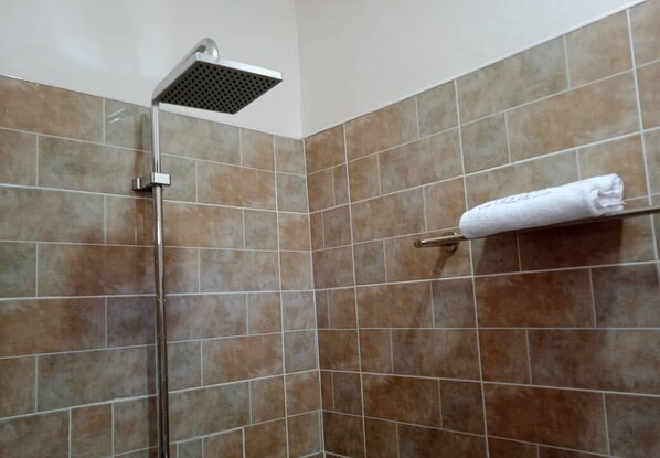 Enjoy a refreshing shower in this well-appointed space with a wall-mounted showerhead and convenient towel rack.