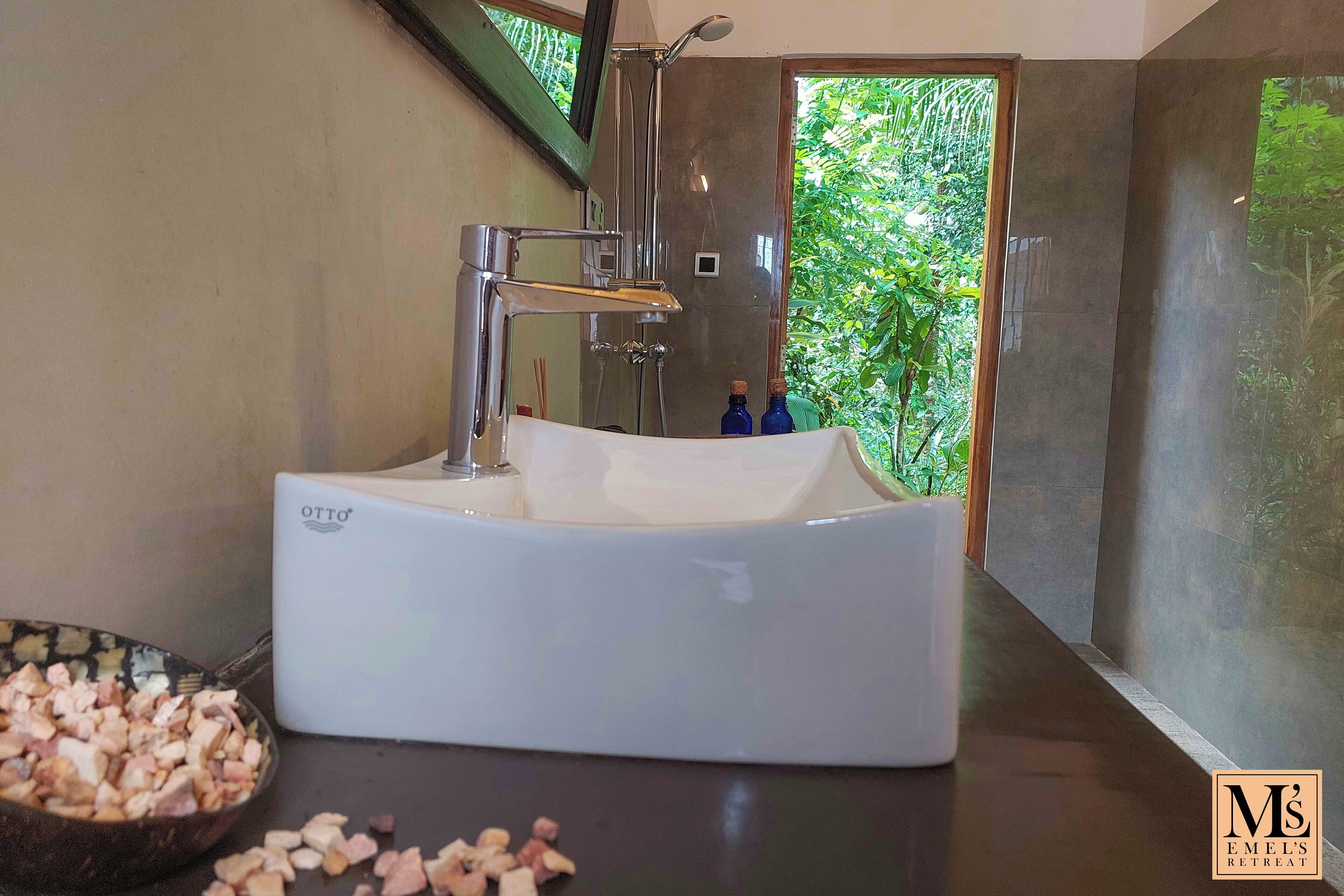 Une salle de bain moderne avec une baignoire sur pieds, un grand miroir et une vue sur la verdure environnante.