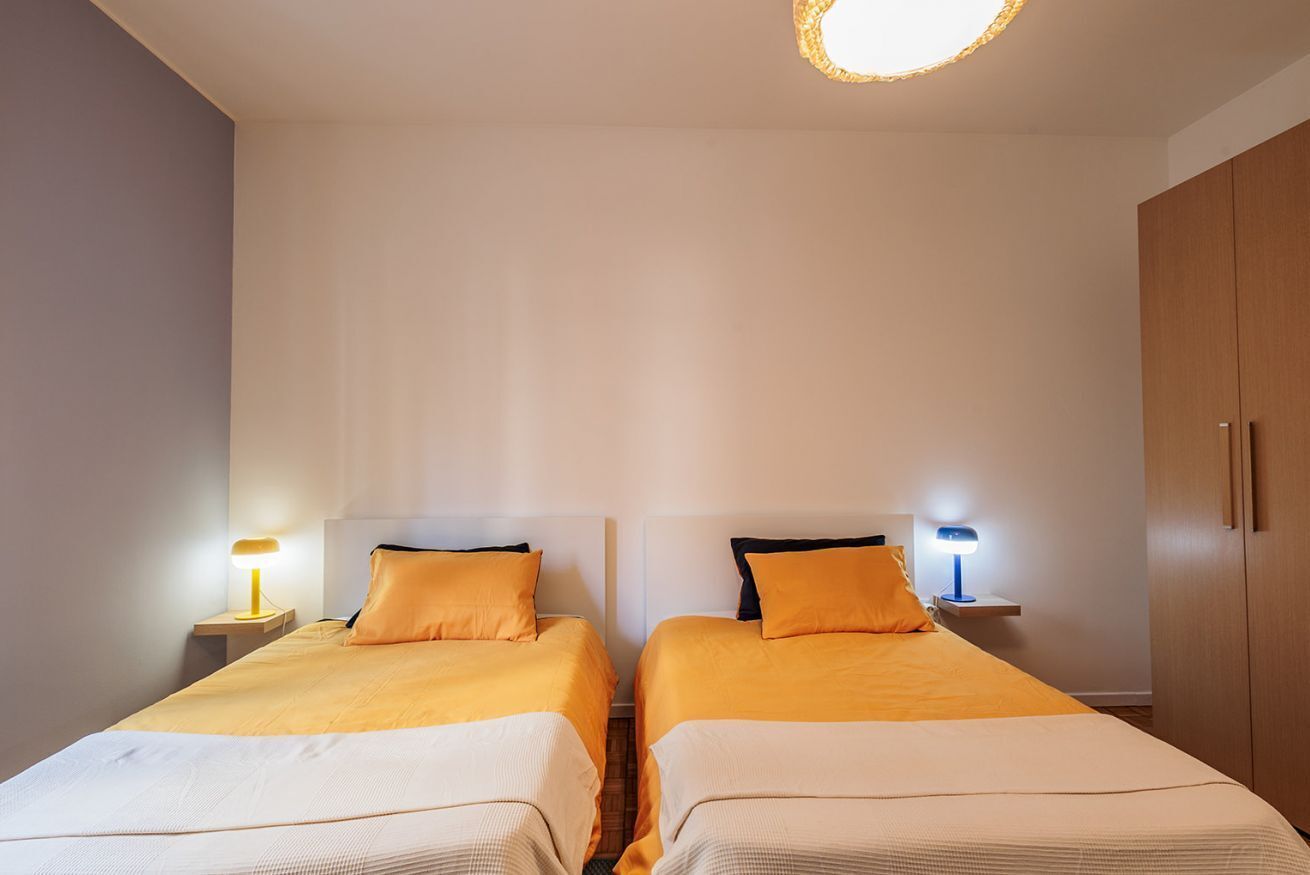 Une chambre double avec deux lits, des tables de chevet avec des lampes et une armoire.