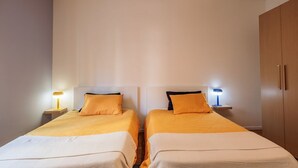 Une chambre double avec deux lits, des tables de chevet avec des lampes et une armoire.