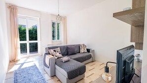 Un salon moderne avec un canapé, une cheminée et une grande fenêtre agrémentée de rideaux.