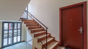 Un escalier avec une rampe en métal menant à une porte en bois.