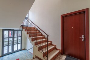 A staircase with a metal railing leading to a wooden door.