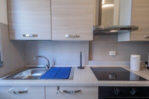 A modern kitchen with a sink, stove, and cabinets.