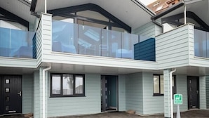 A modern building with a flat roof, large windows, and a covered entrance area. - Seaside 3BD Retreat with Balcony and Stunning Views (Westward Ho!)