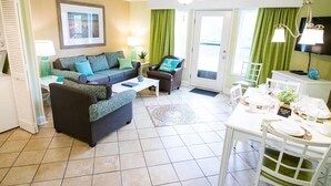 A living room with a sofa, coffee table, and dining table set up.