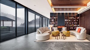 A modern living room with a fireplace, large windows, and a bookshelf. - In Cloud Resort Hotel (Yongzhou)