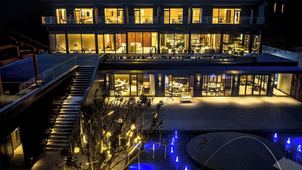 A multi-story building with a pool and outdoor lighting. - In Cloud Resort Hotel (Yongzhou)