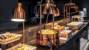 A buffet setup with various food items and copper lighting fixtures. - In Cloud Resort Hotel (Yongzhou)