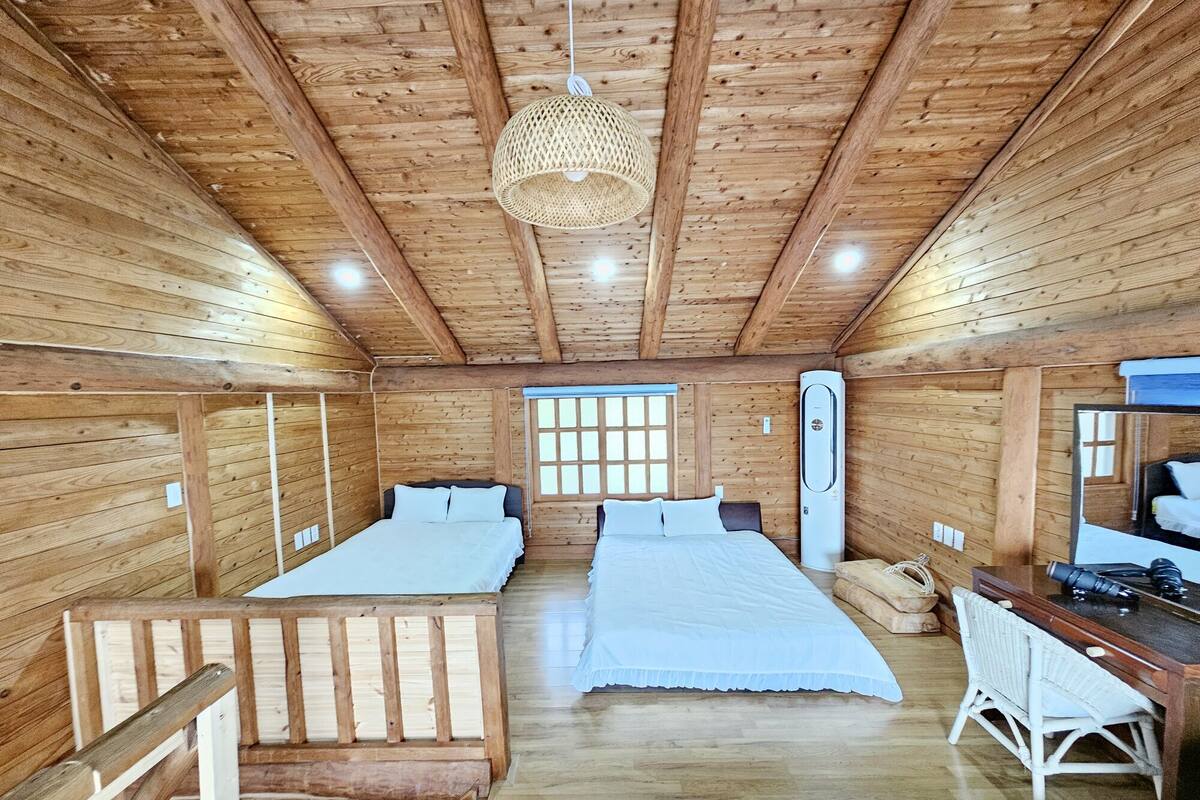 A cabin with two beds, a desk, and a large window.