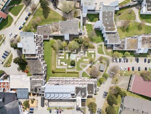 Vue aérienne d’un campus comprenant plusieurs bâtiments, des aires de stationnement et des espaces verts.