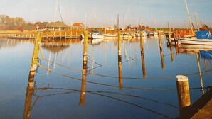 Un port de plaisance avec des bateaux amarrés, une eau calme et un ciel dégagé.