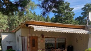 Ein Haus mit Terrasse, kleinem Garten und Teich.